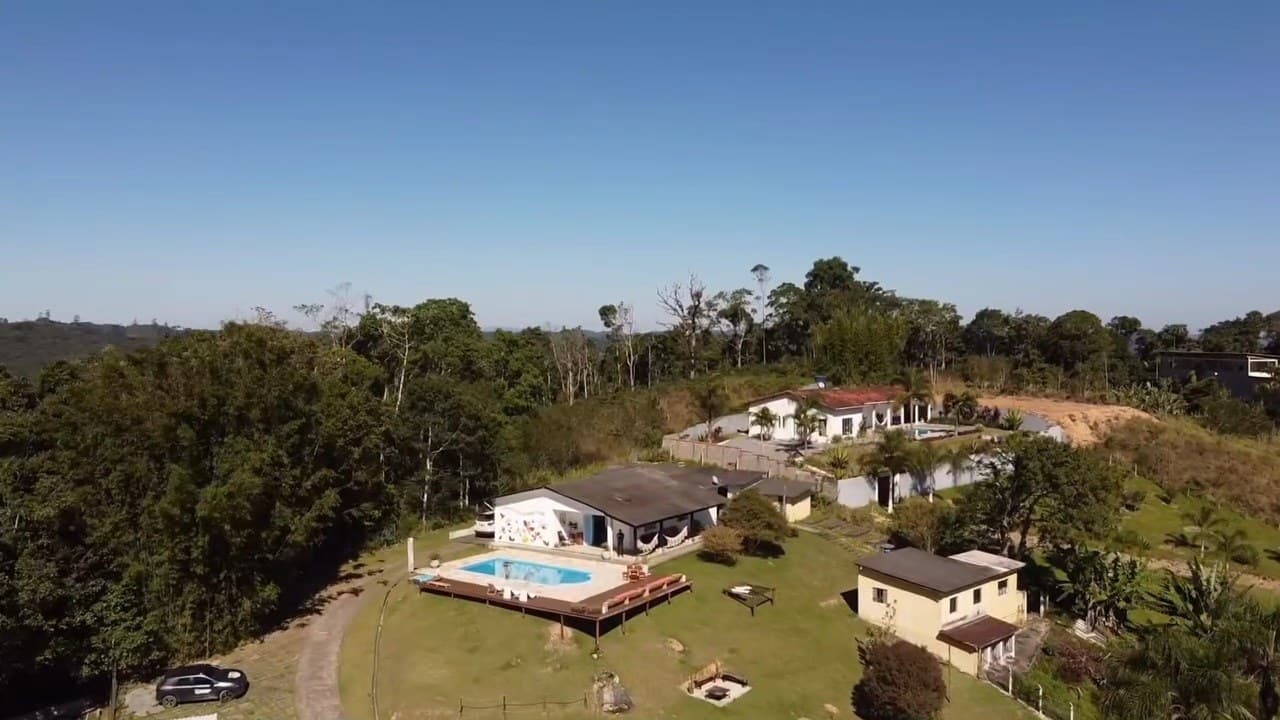 A chácara vista do alto, no topo da colina, cercada pela Mata Atlântica