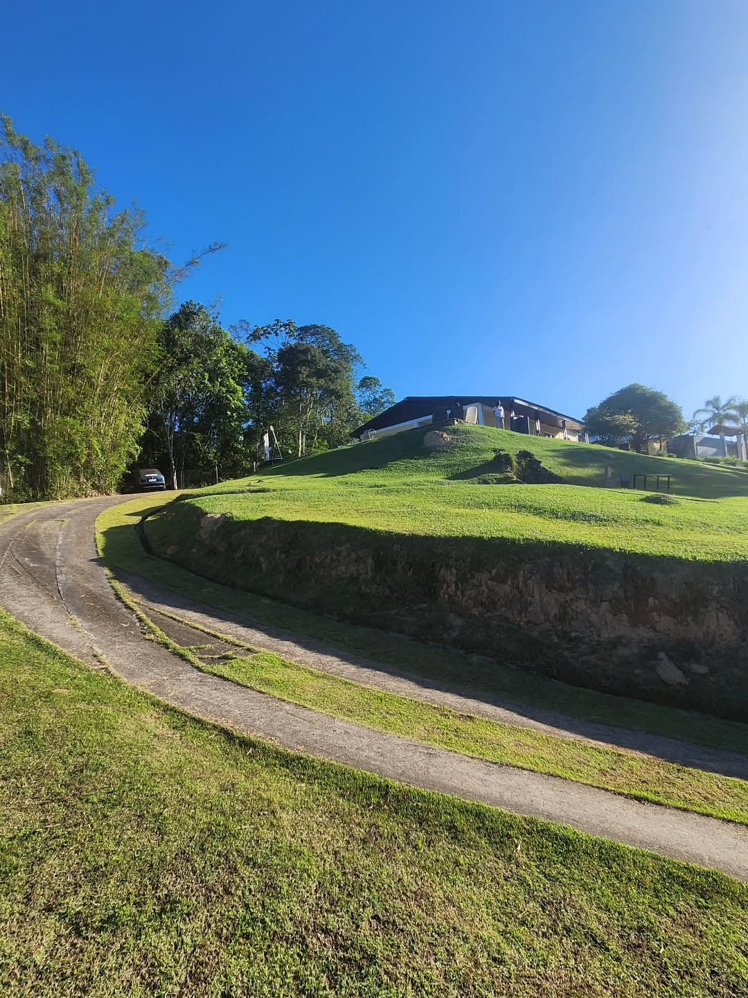 O caminho curvo pelo gramado até a casa no alto da colina