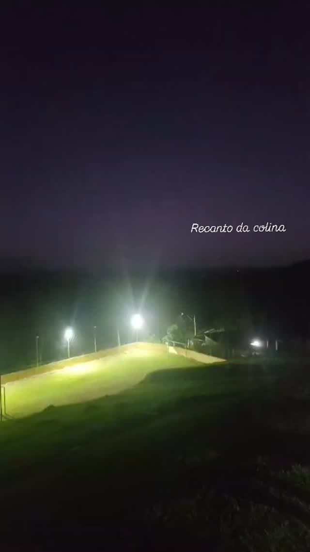 O gramado iluminado à noite, no alto da colina
