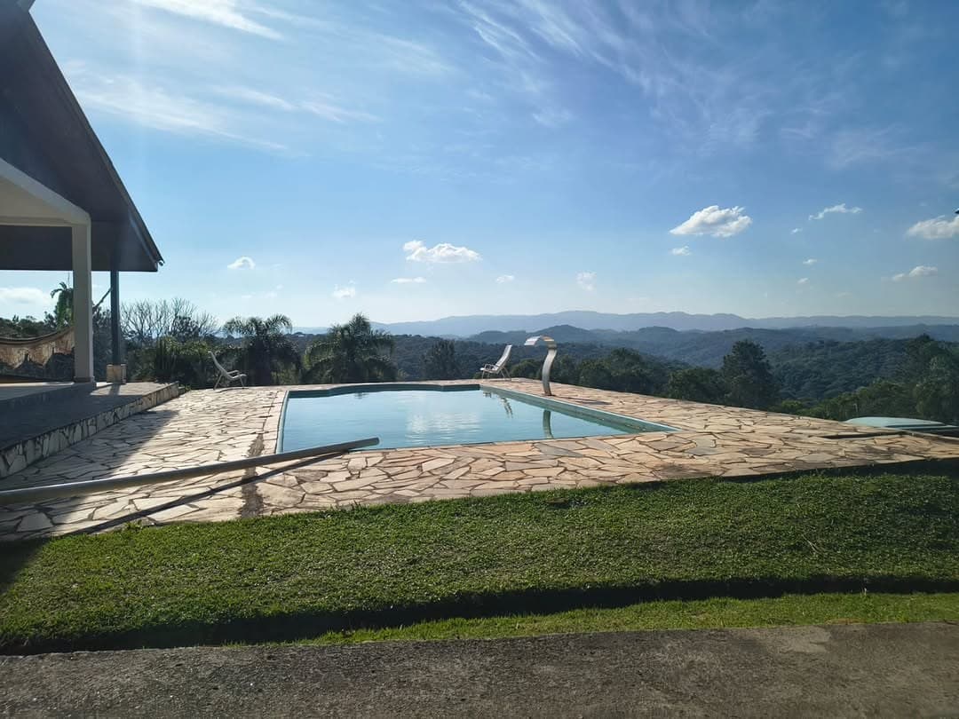 Piscina com cascata e o horizonte de serras ao fundo