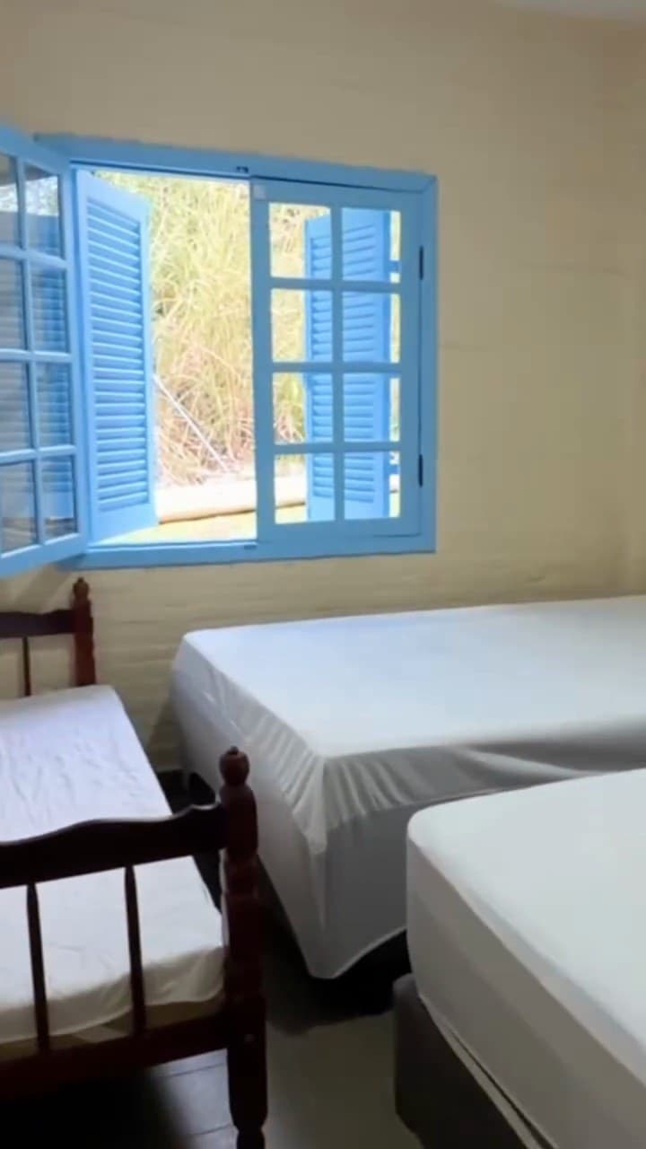 Quarto com camas e janela azul