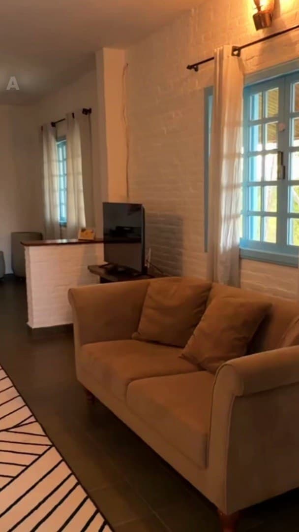 Sala com sofá, janela azul e piso escuro