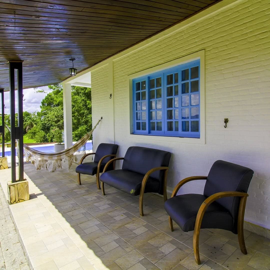 Poltronas na varanda da casa, ao lado das janelas azuis